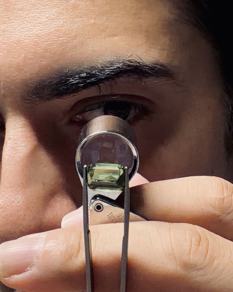 Vector Stones founder inspecting a gemstone with a loupe